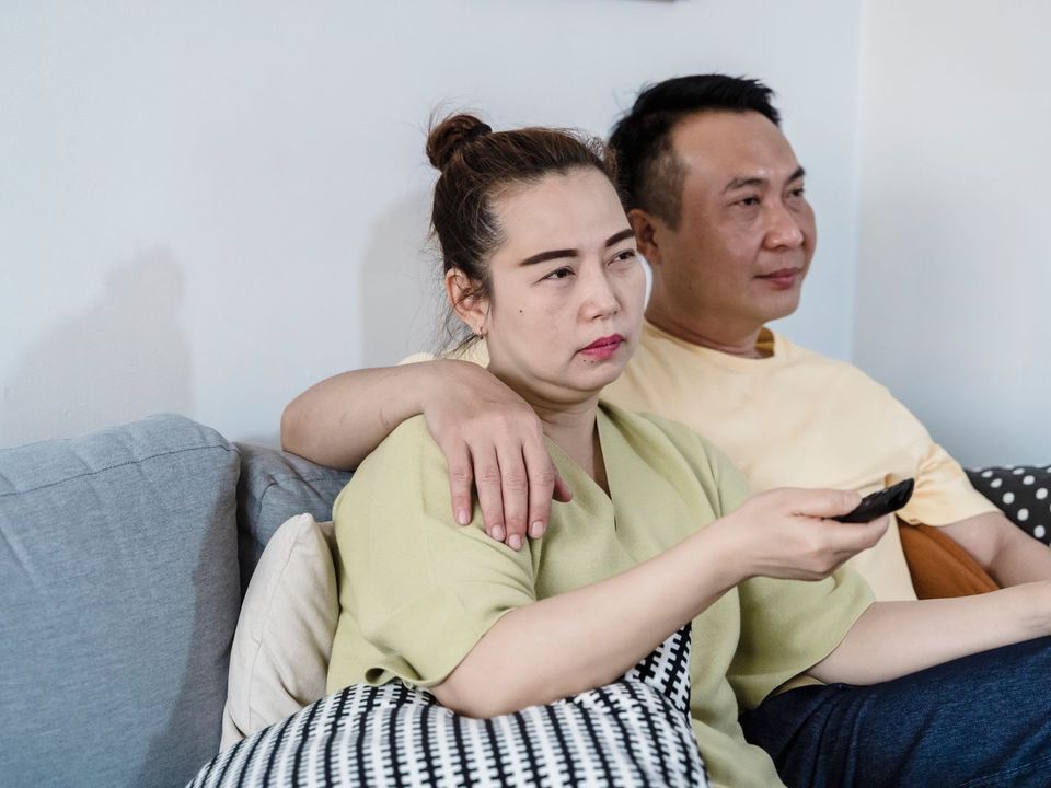 ソファでテレビを見てくつろぐ夫婦